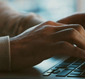 Pessoas conferindo em um computador sobre o evento de Inteligência Artificial na cibersegurança.