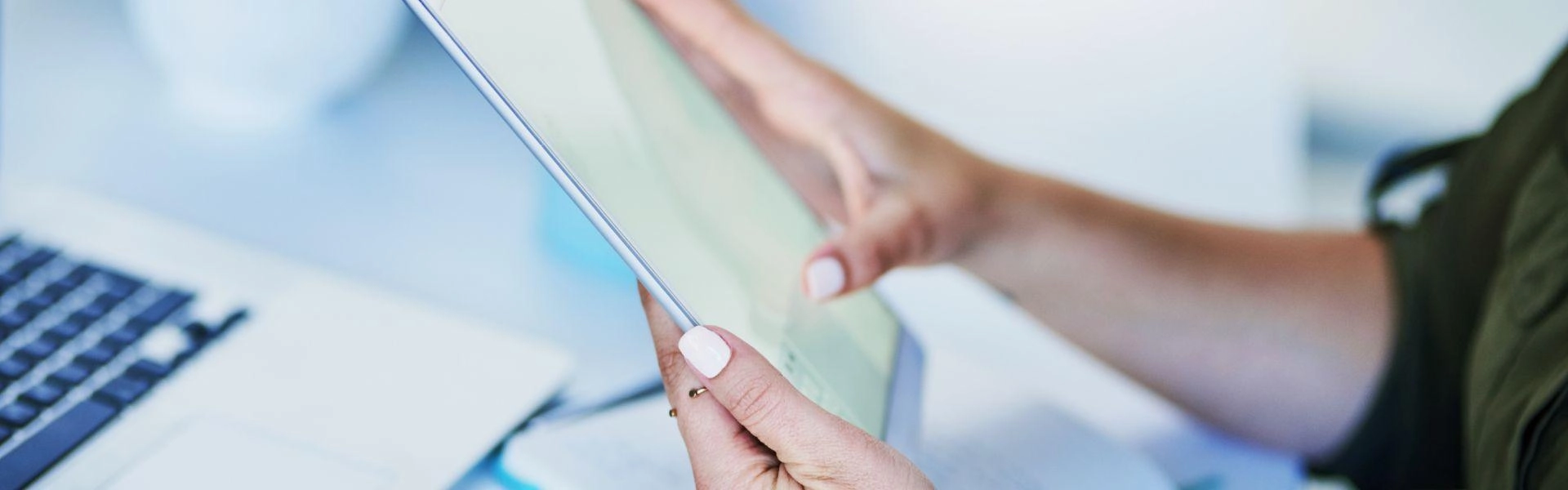 Mão feminina segurando um tablet enquanto confere a acessibilidade no e-commerce.