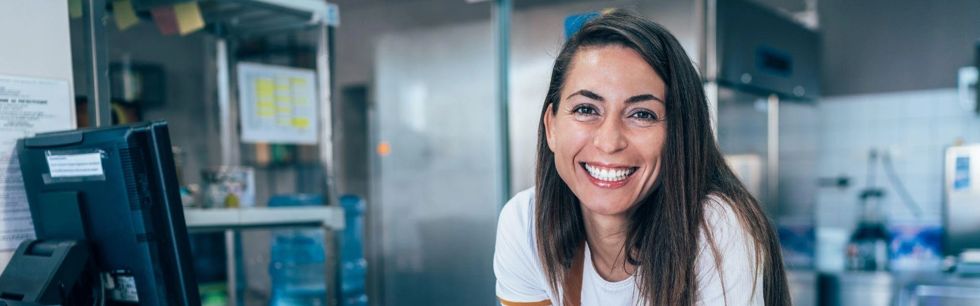 Mulher dona de pequeno negócio sorrindo.