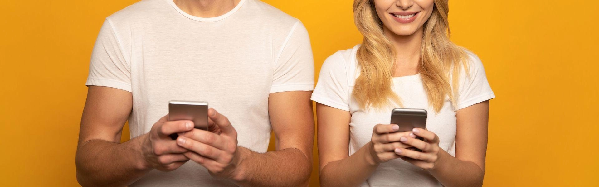 Homem e mulher conferem a internet 5G no celular.