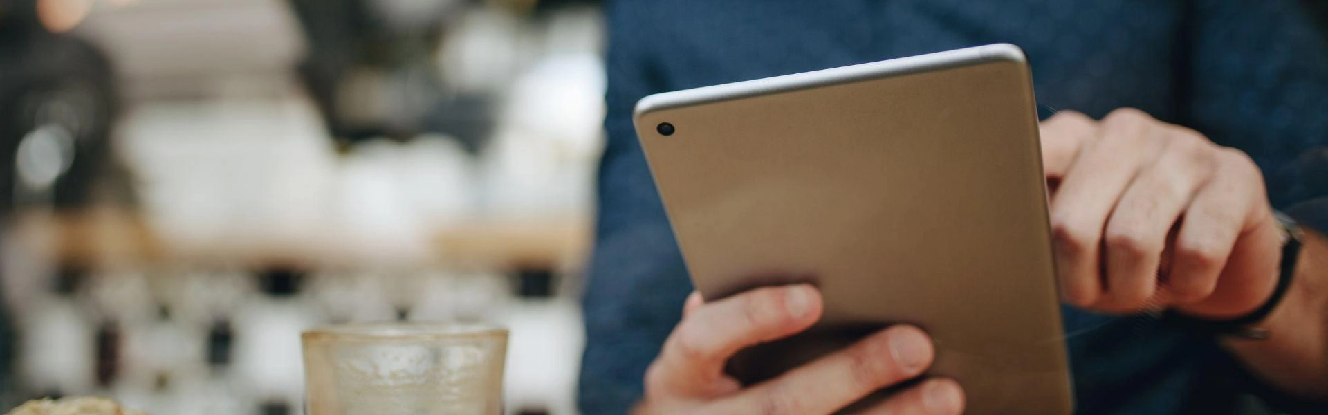 Homem conferindo em tablet a plataforma de formalização de MEIs do Santander.