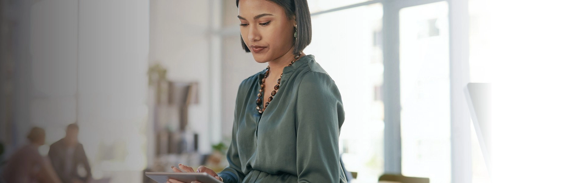 Mulher oriental usando tablet em ambiente corporativo