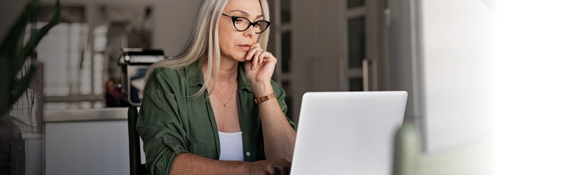 Mulher branca e com cabelos longos loiros concentrada no tema internacionalização em seu notebook