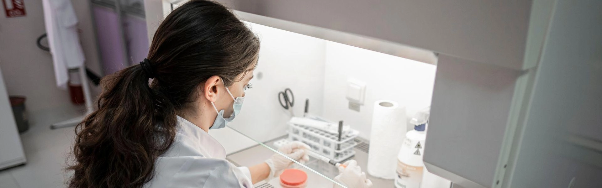 Mulher mexendo com equipamentos de laboratório médico.
