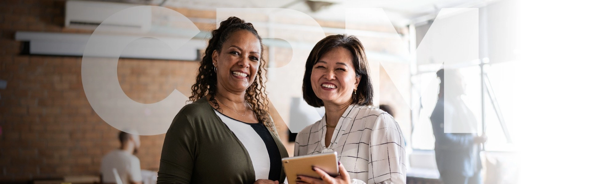 Duas mulheres sorrindo e felizes com os resultados da aplicação do CRM.