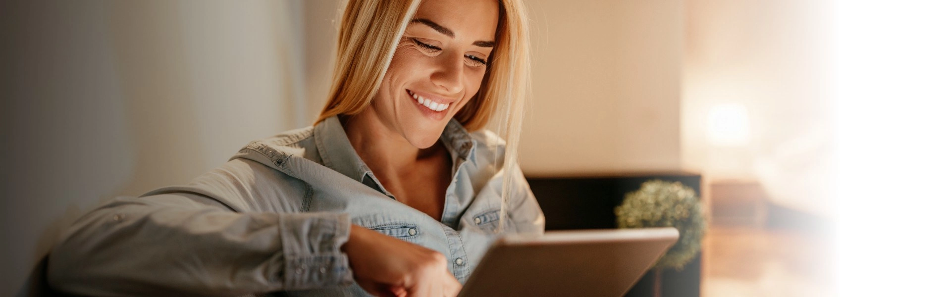 Mulher branca sorrindo enquanto lê sobre atendimento ao cliente.