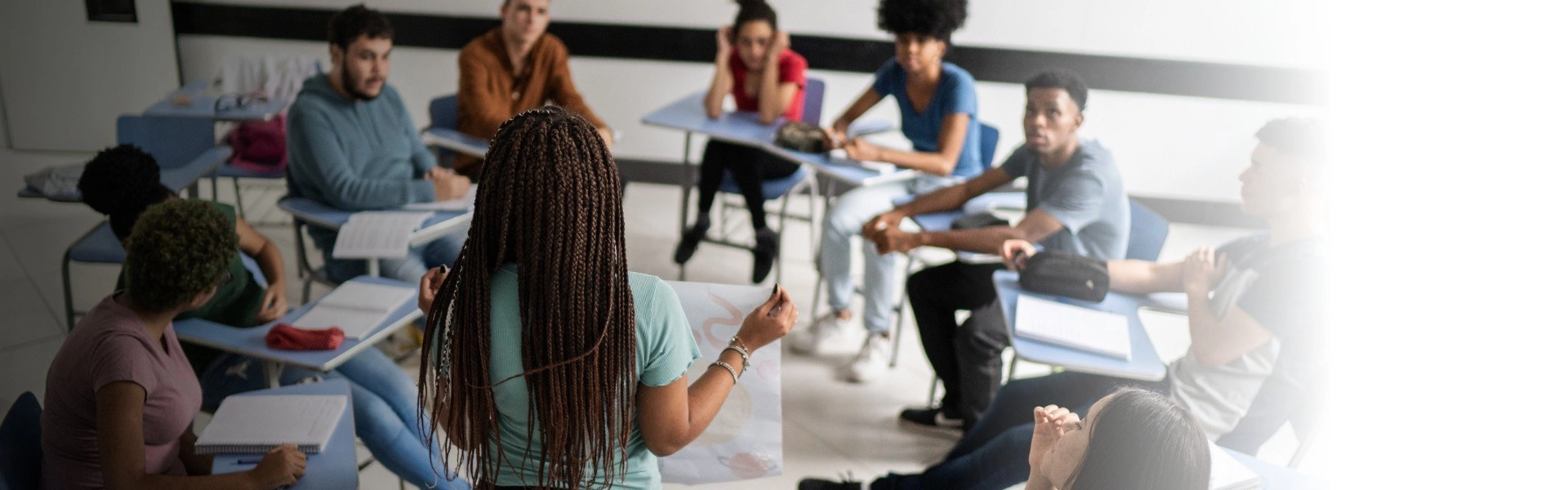 Grupo de estudantes do Ensino Médio em roda aprendendo empreendedorismo em sala de aula