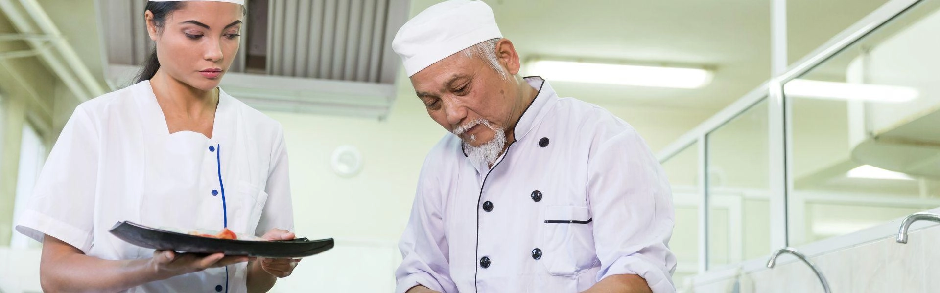 Dois chefs de cozinha cozinhando em conjunto.
