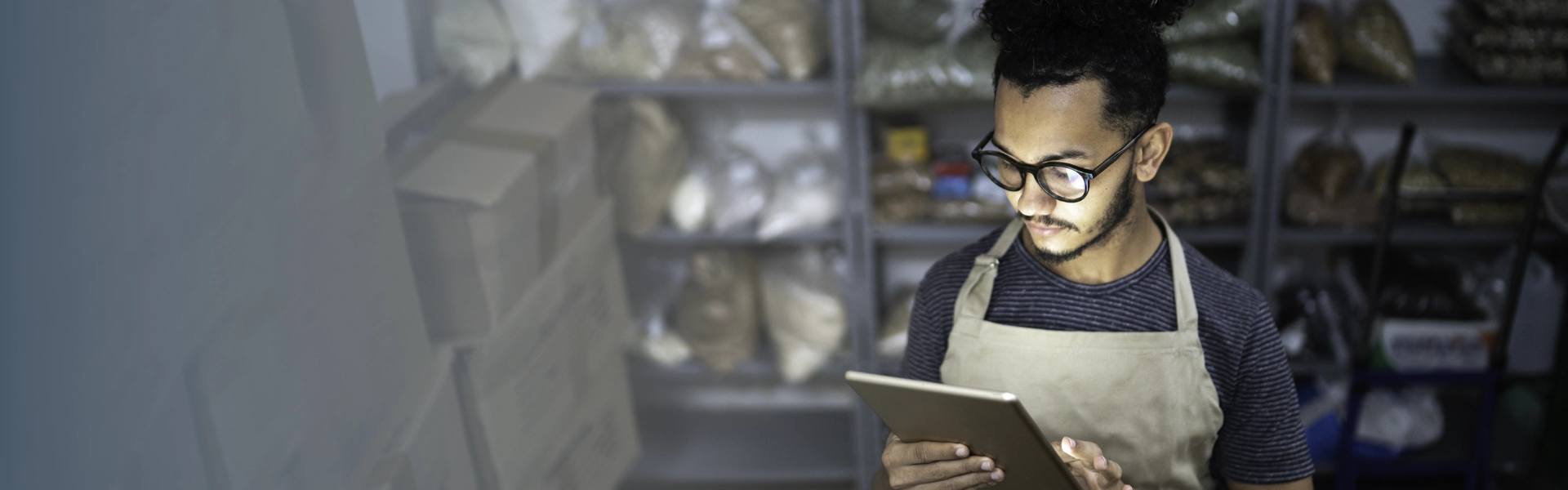 Homem negro usando óculos de grau acessa e-book do Sebrae em seu tablet.