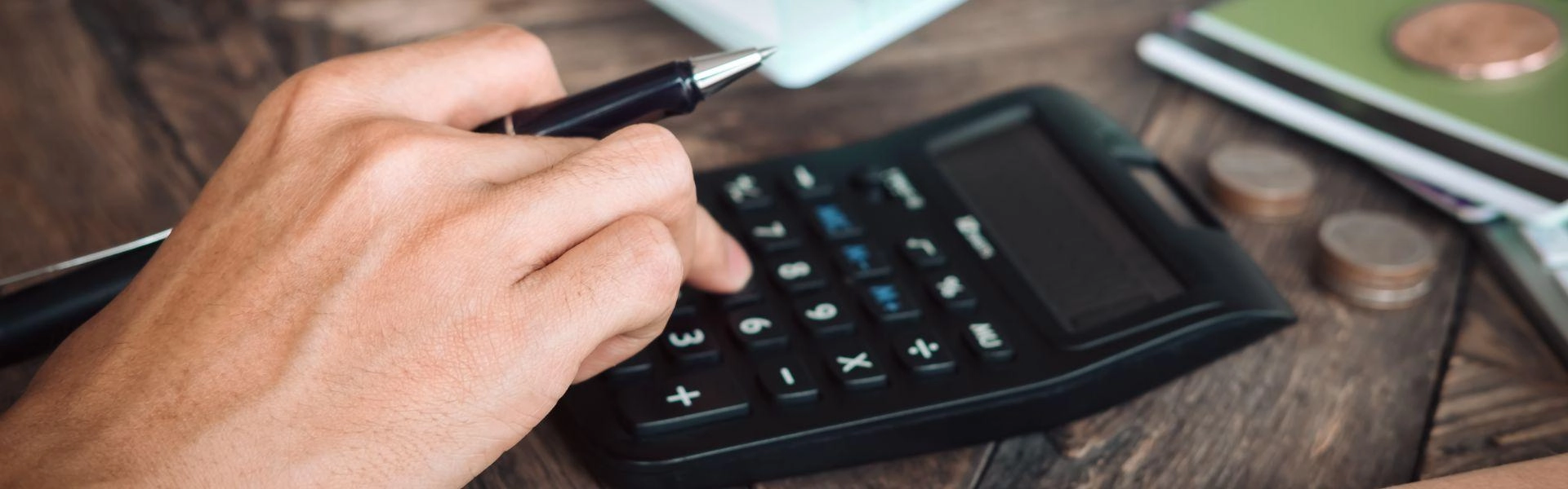 Pessoa fazendo contas na calculadora.