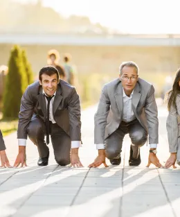 Quatro pessoas agachadas em posição prontas para correr.