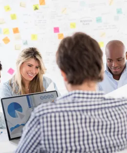 Grupo de pessoas analisando dados em papéis e computador