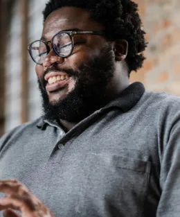 Homem negro estudando em um tablet, sorrindo feliz