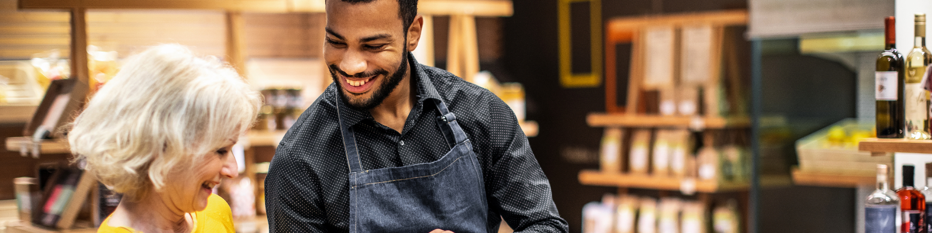 Homem vendendo produtos para uma cliente em loja, destacando a importância da diversificação para vender mais