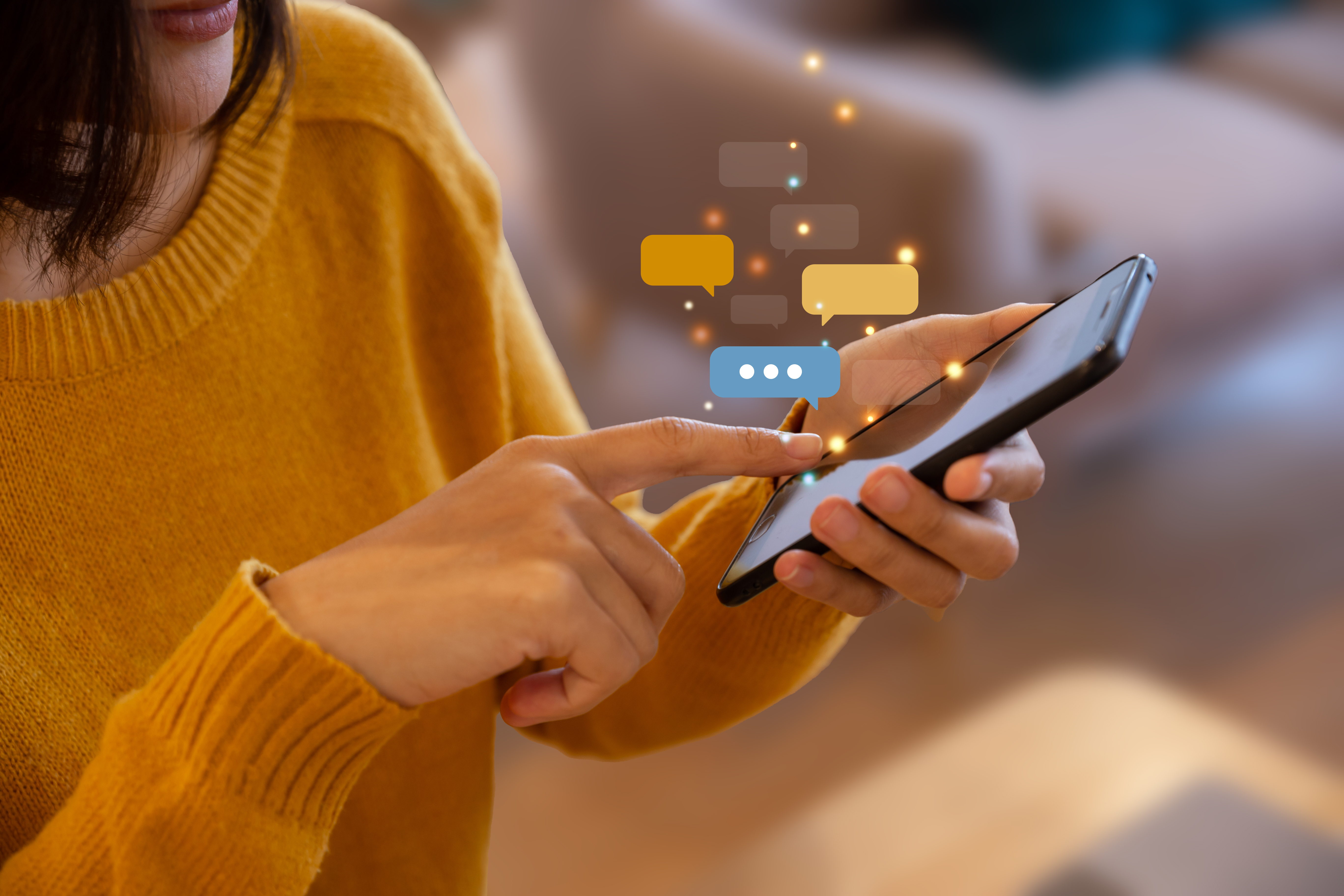Mulher usando smartphone para comunicação digital, com mensagens visíveis na tela, simbolizando interações online.