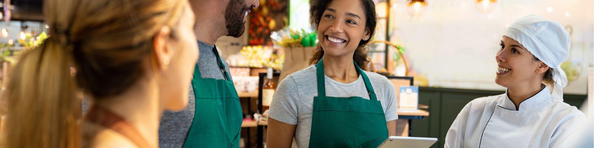 Equipe de pequenos empreendedores em mercado local trocando ideias e fortalecendo a inovação social nos negócios.