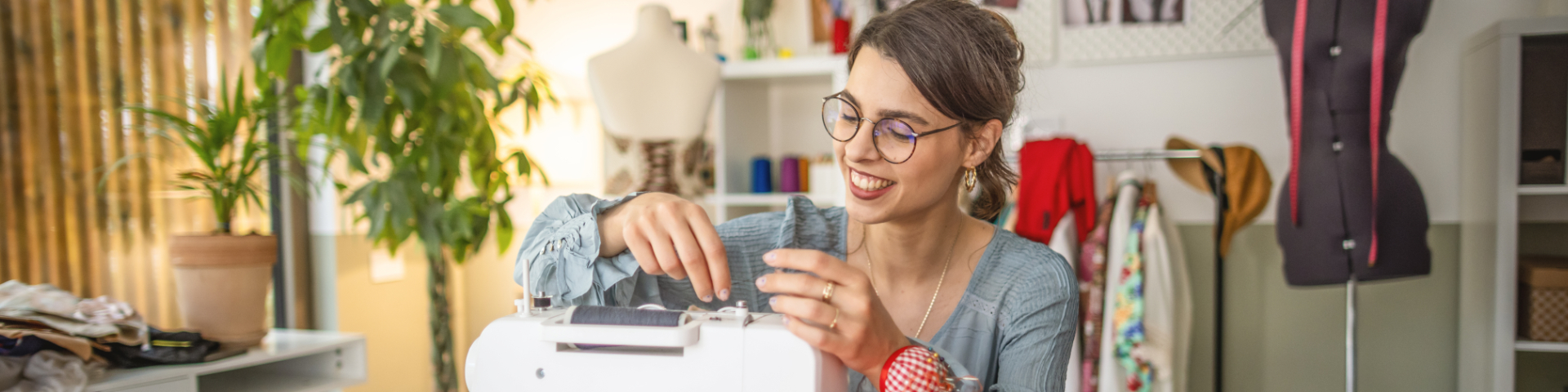 Jovem empreendedora costurando roupas em sua loja, representando o perfil do nanoempreendedor, com dedicação ao seu negócio.