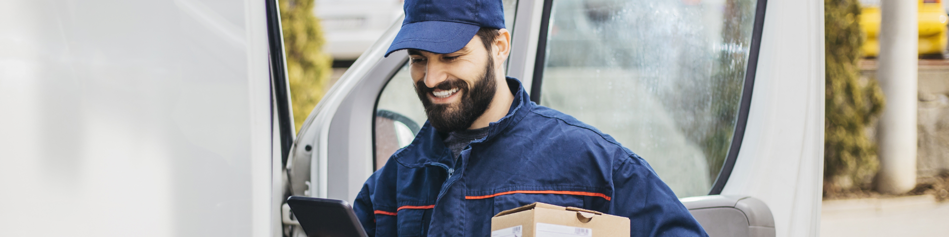 Nanoempreendedor utilizando um celular ao lado de sua van de serviços de entrega, representando inovação e empreendedorismo no setor de pequenas empresas.